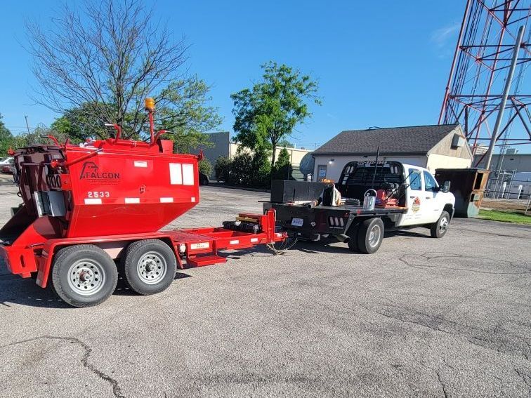 A red truck is parked next to a white truck in a parking lot.