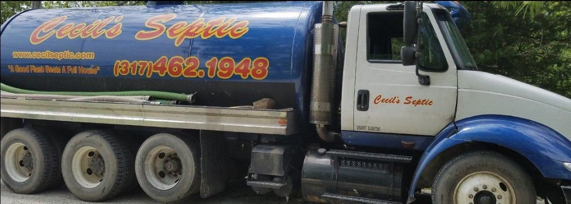 A person is cleaning a septic tank with a hose.