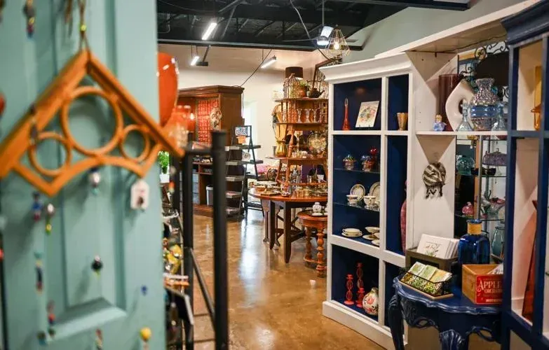 Interior shop with wooden shelves displaying various items, blue and orange accents.