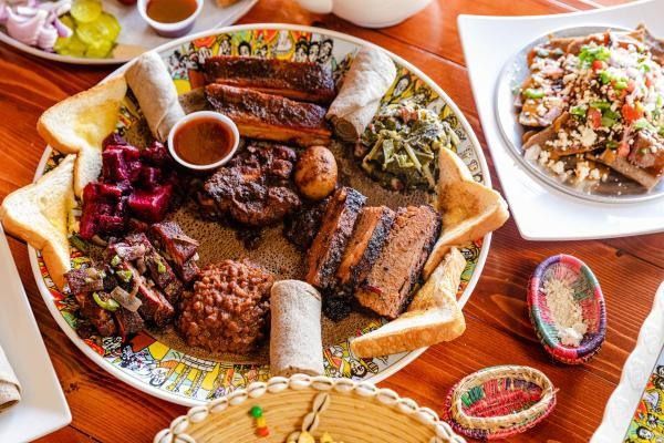 Ethiopian food platter: various meats, vegetables, sauces, and injera bread on a colorful plate.