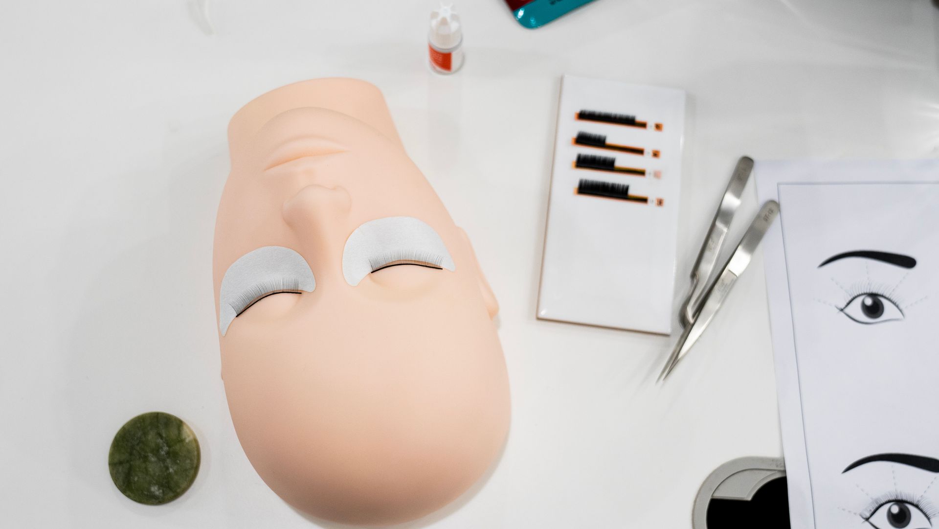 Person bei Wimpernlifting; Creme wird mit einem Pinsel auf die Wimpern aufgetragen. Augenklappe angelegt.