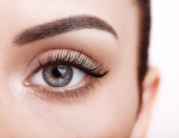 Person bei Wimpernlifting; Creme wird mit einem Pinsel auf die Wimpern aufgetragen. Augenklappe angelegt.