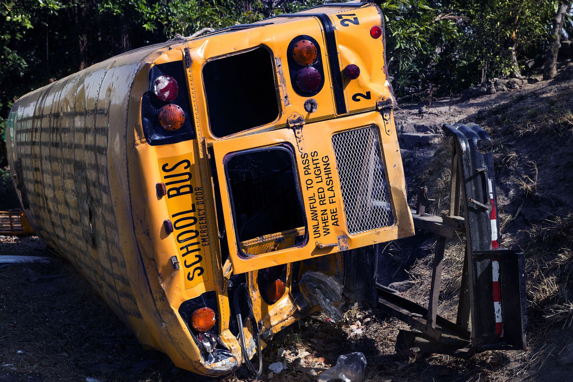 A yellow school bus is turned over on its side