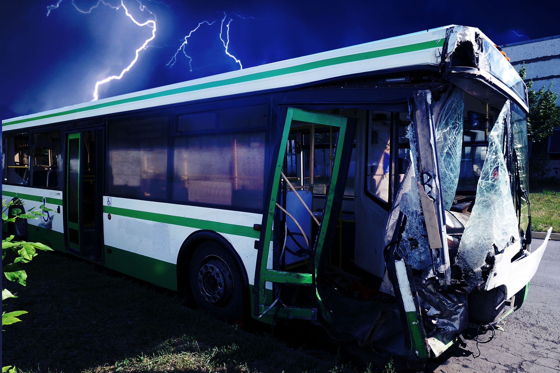 A green and white bus with a broken windshield