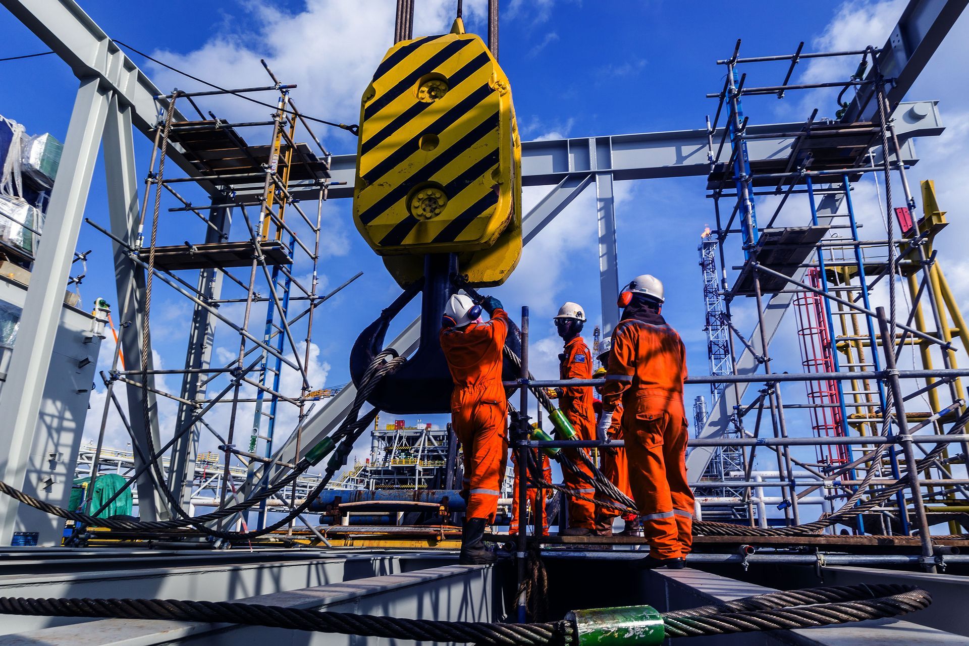 A group of construction workers are working on a large crane.