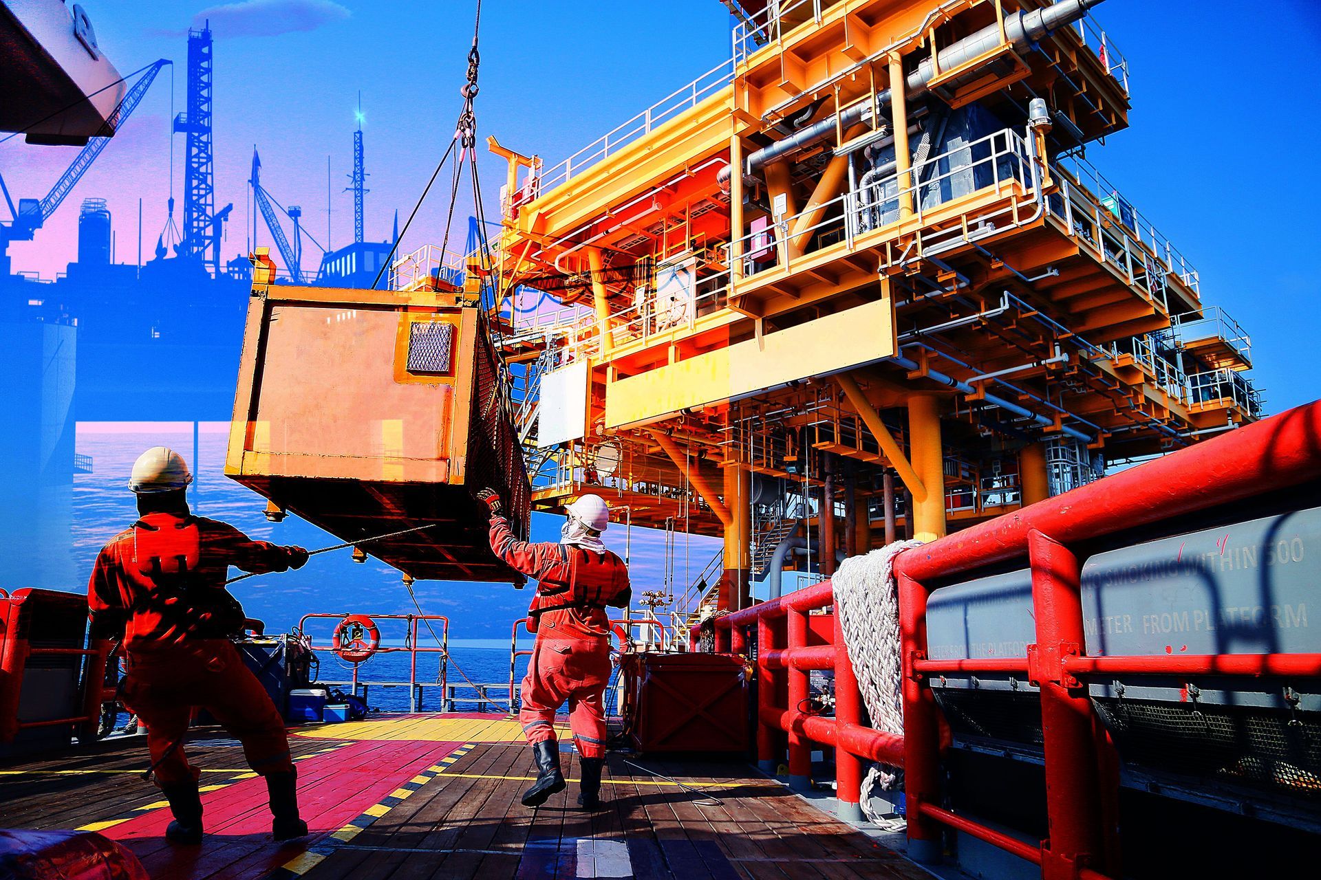 Two men are lifting a large box on top of an oil rig.