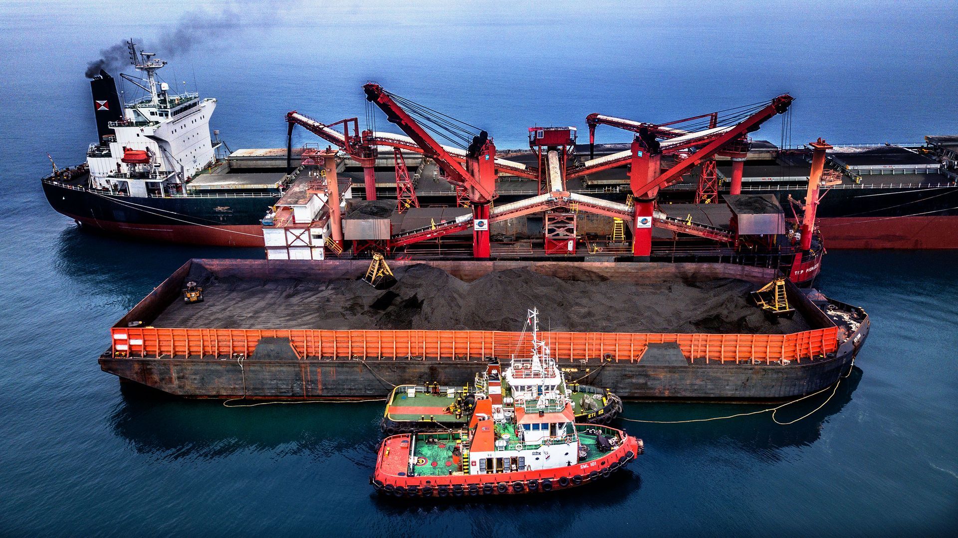 Two large ships are docked next to each other in the ocean