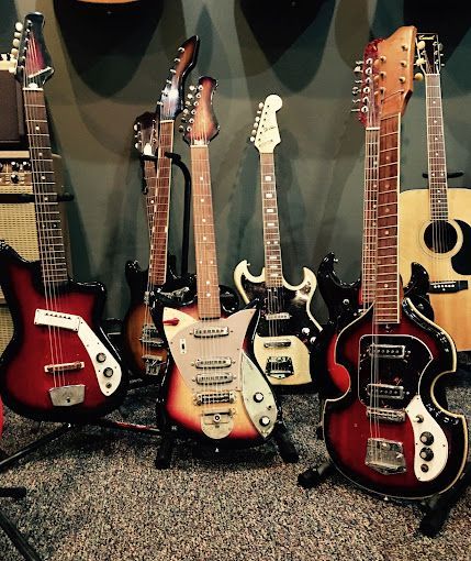 A group of guitars are lined up in a room