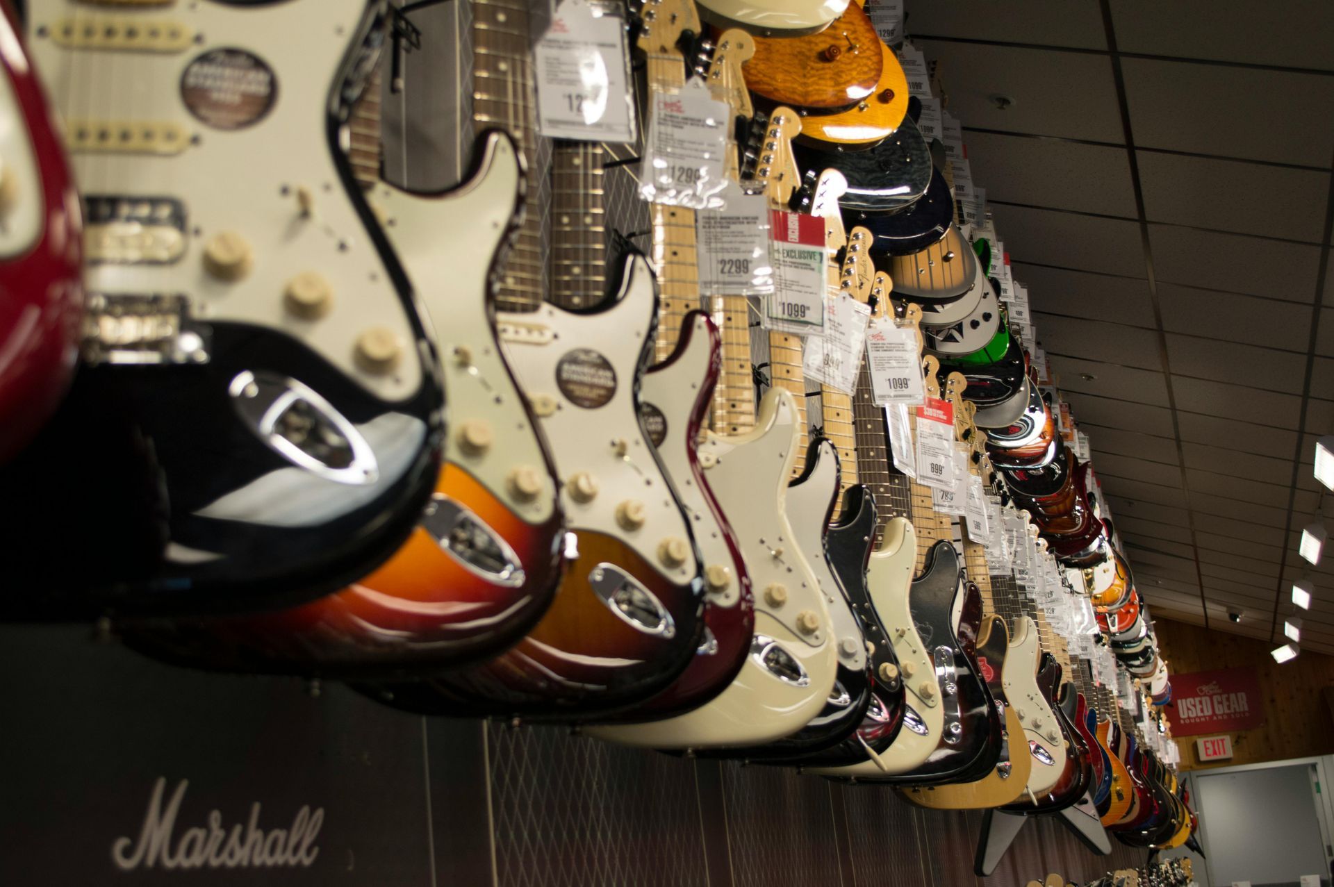 A row of marshall electric guitars hanging from the ceiling