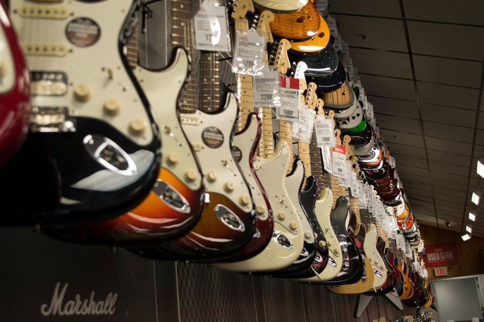 A row of marshall electric guitars hanging from the ceiling