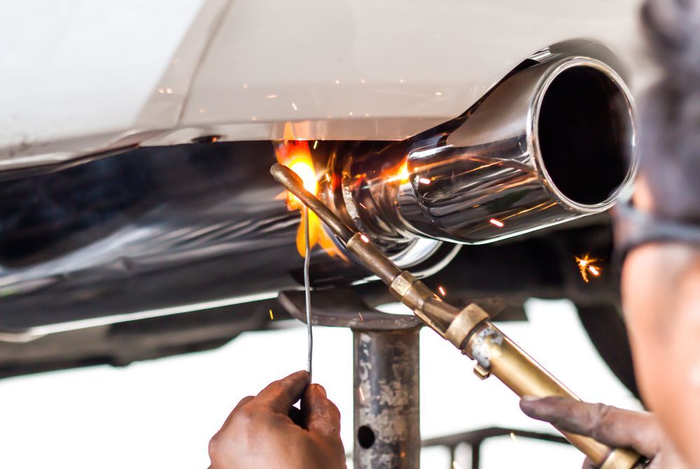 A Person Welding a Chrome Exhaust Pipe Onto a Car, Sparks Flying — SPW Engineering & Powdercoating In Ballarat, VIC