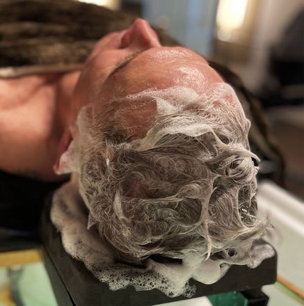 A man is getting a head massage with water