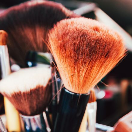 A bunch of makeup brushes are sitting on a table