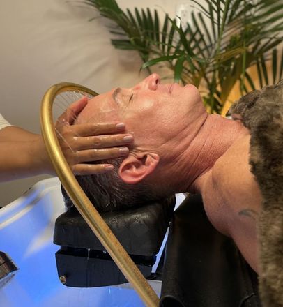 A man is getting a head massage with water