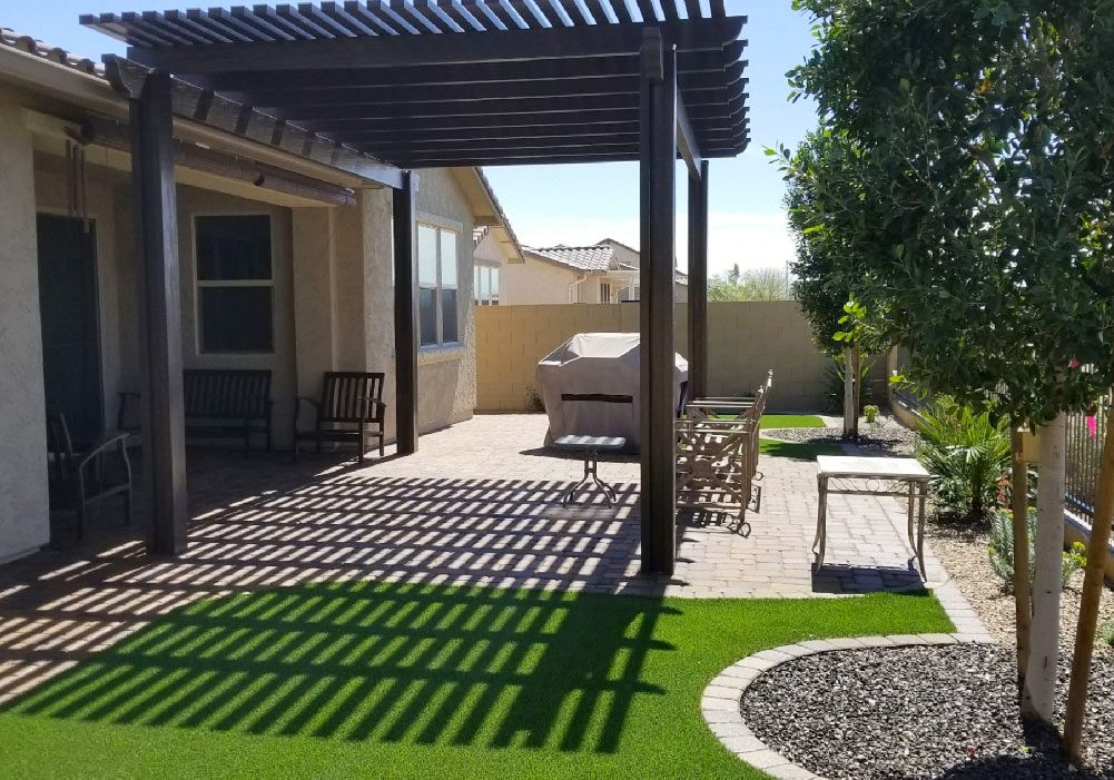 There is a pergola in the backyard of a house.