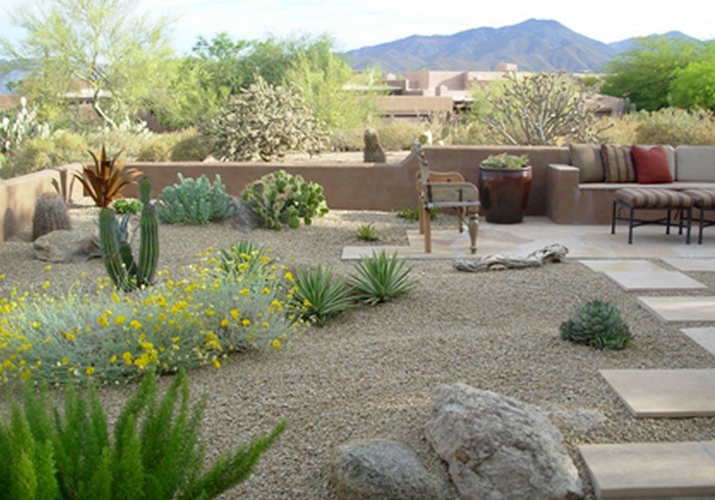 A patio area with a couch and chairs and mountains in the background