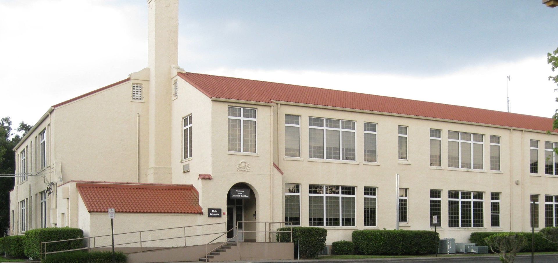 A large white building with a red tile roof
