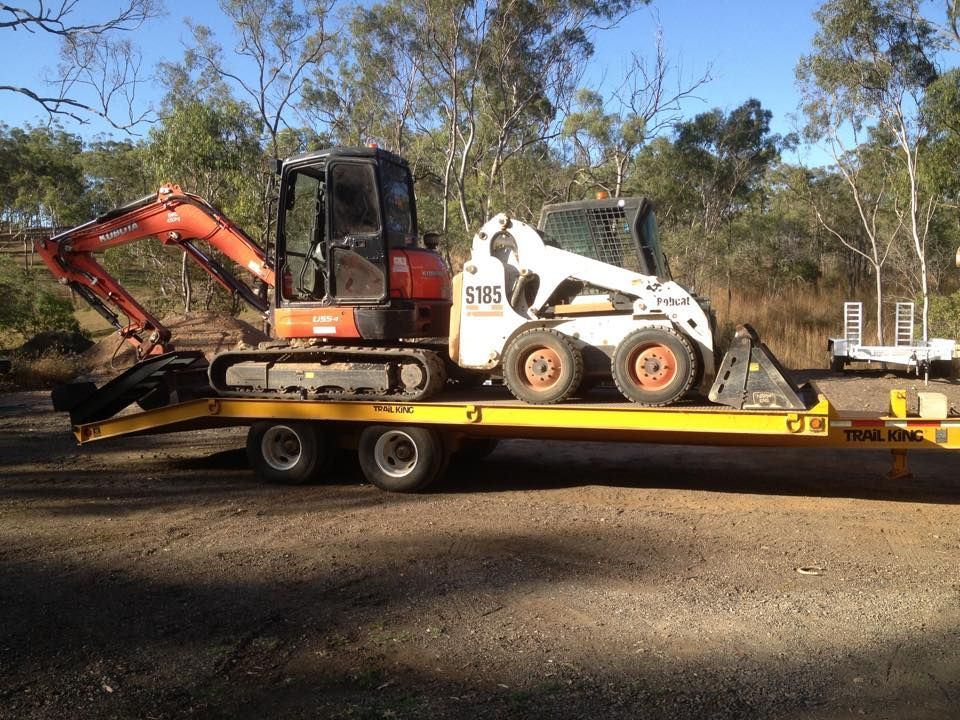 A Bulldozer is Loading Dirt Into a Dump Truck — Eddy’s Excavations & Bobcat Hire In Wurdong Heights, QLD