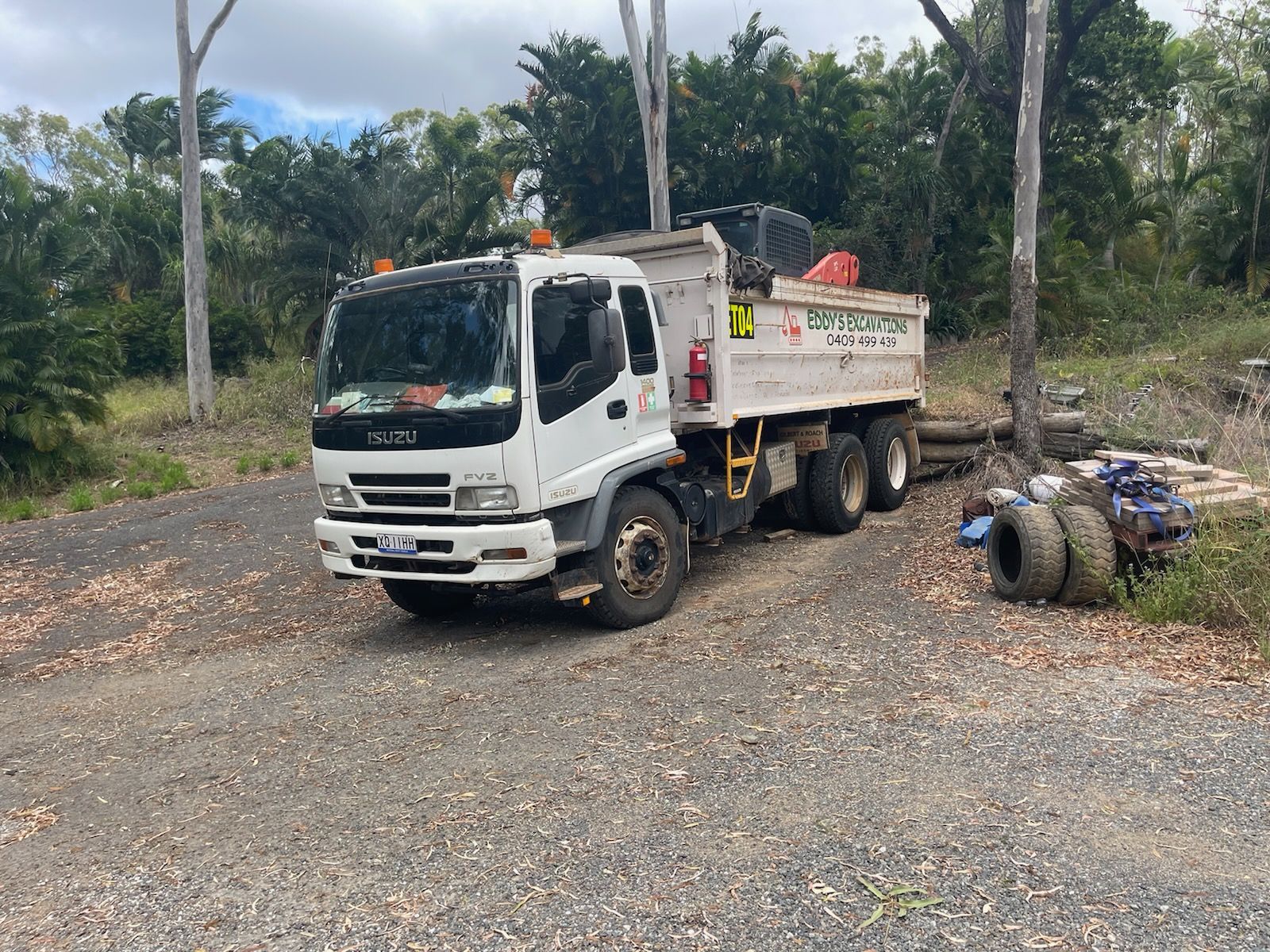 A Bulldozer is Driving Down a Dirt Road — Eddy’s Excavations & Bobcat Hire In Gladstone, QLD