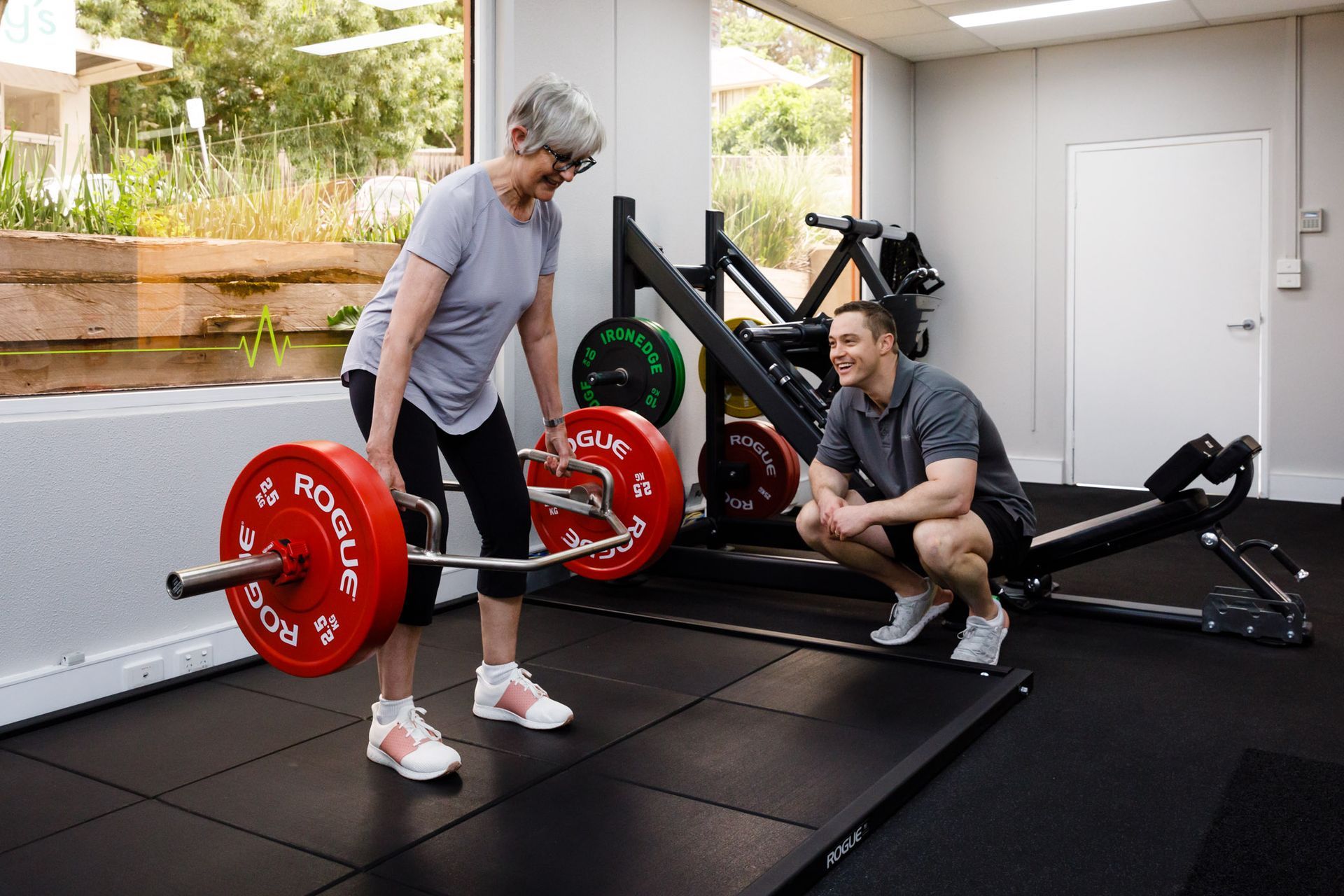 Three men are posing for a picture in a gym.