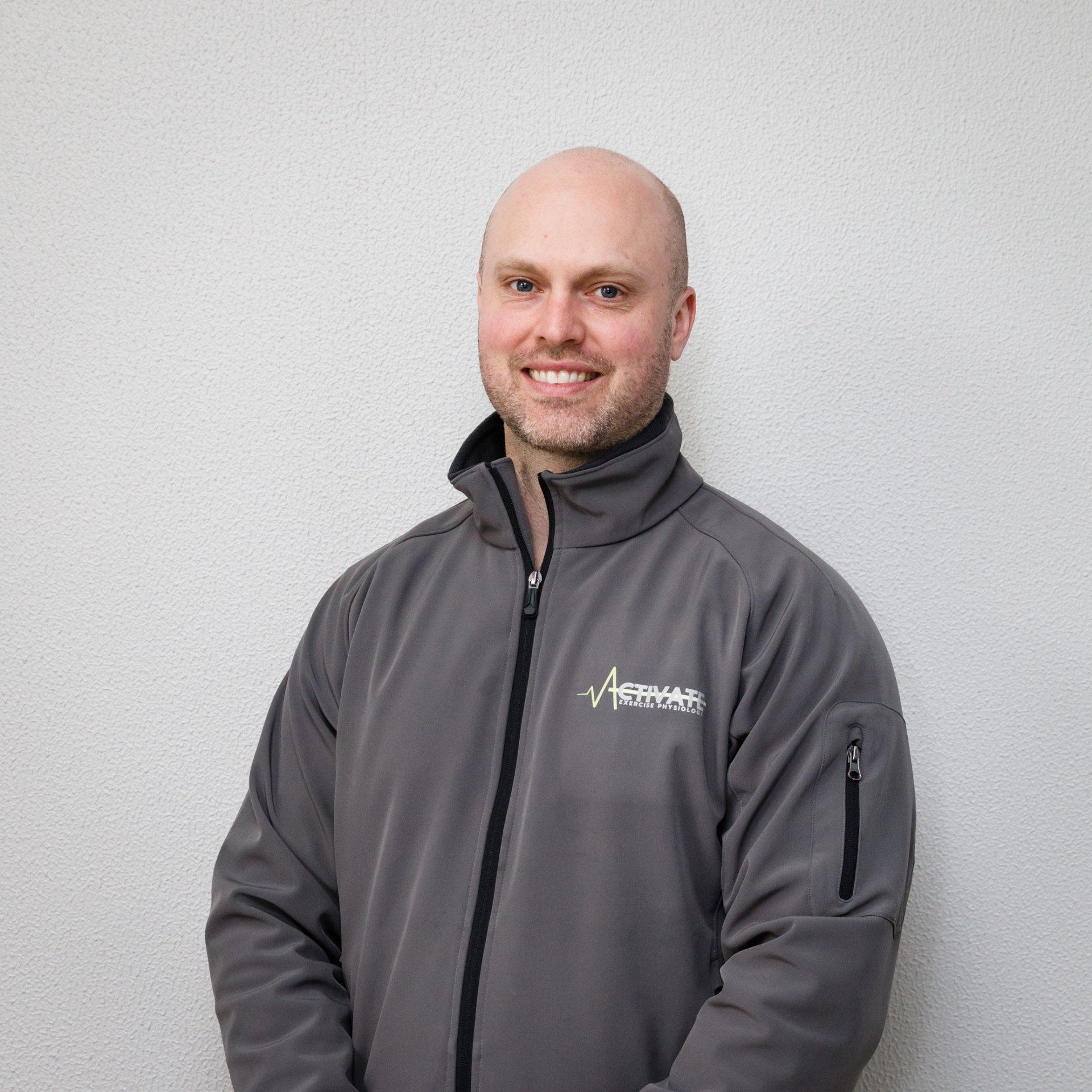 A man wearing a grey jacket with the word abercrombie on it