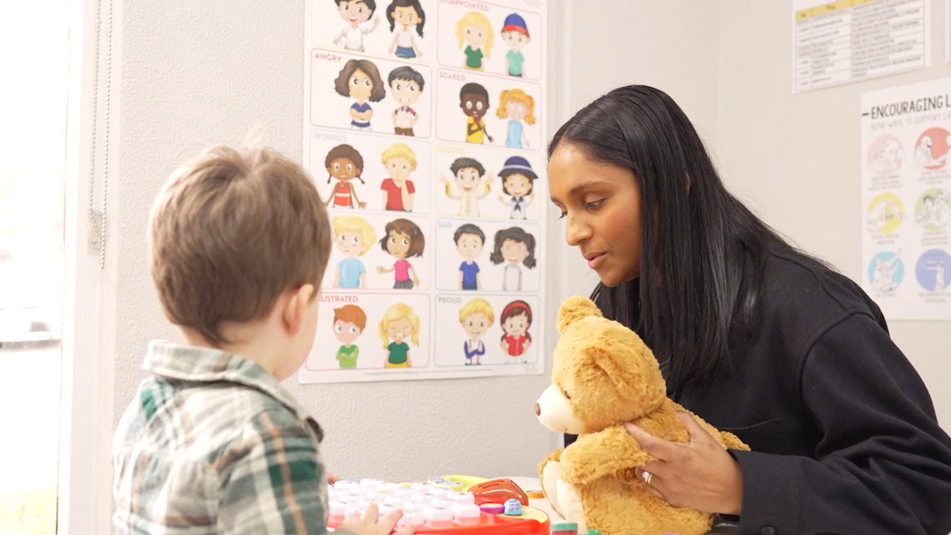 A man is helping a woman do exercises in a gym.