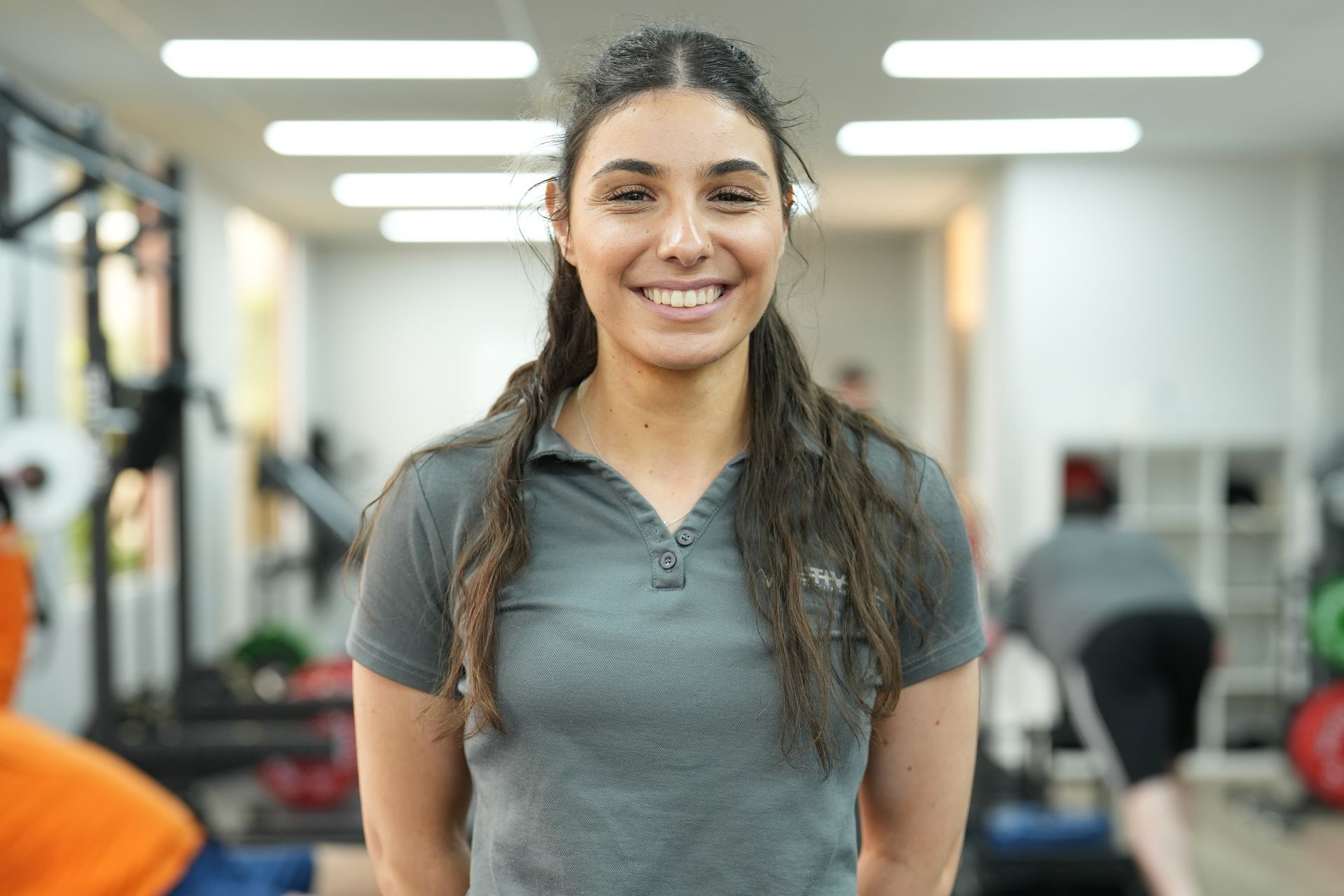 A woman is smiling for the camera in a gym.