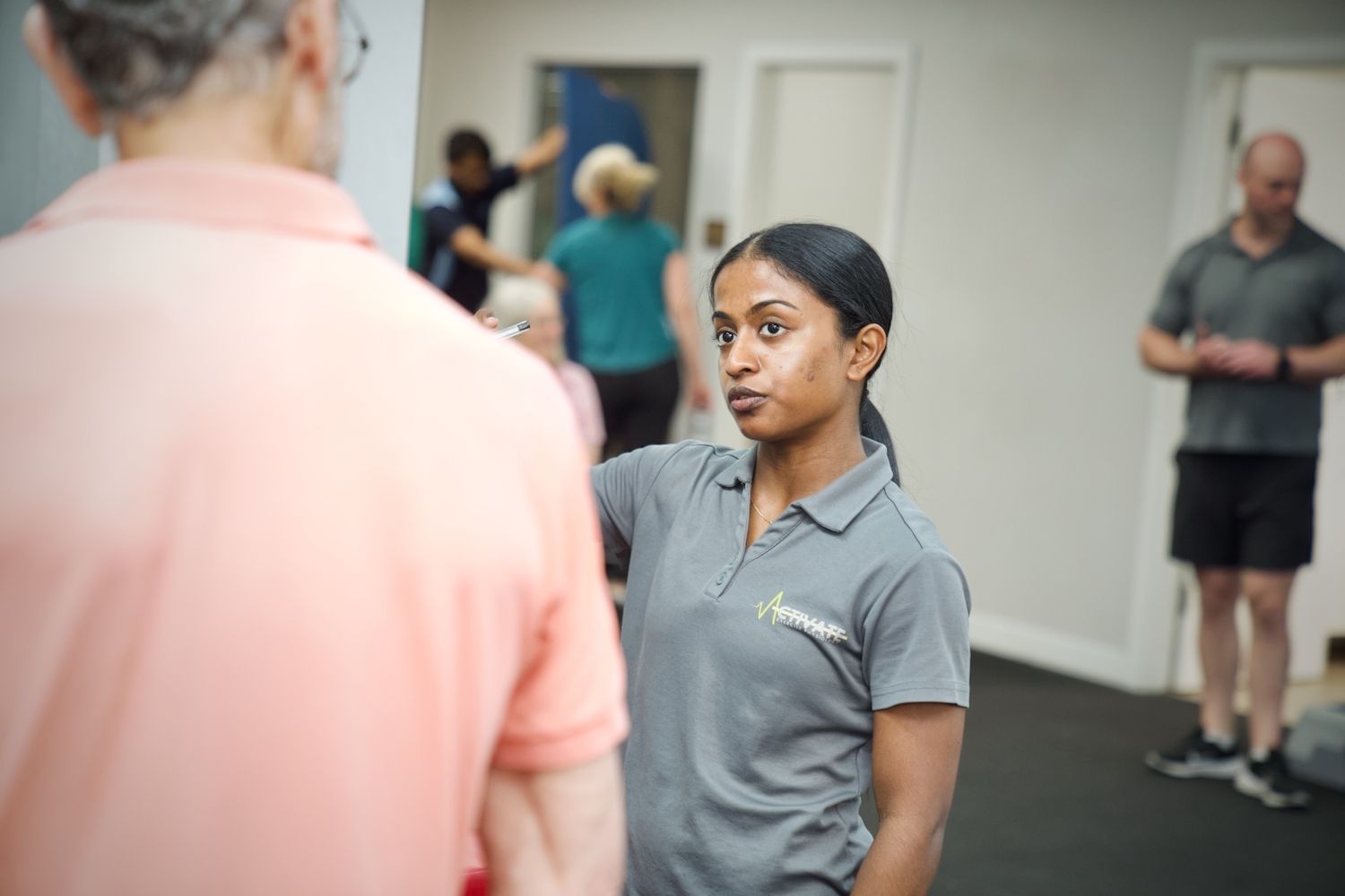 A woman is talking to a man in a gym.