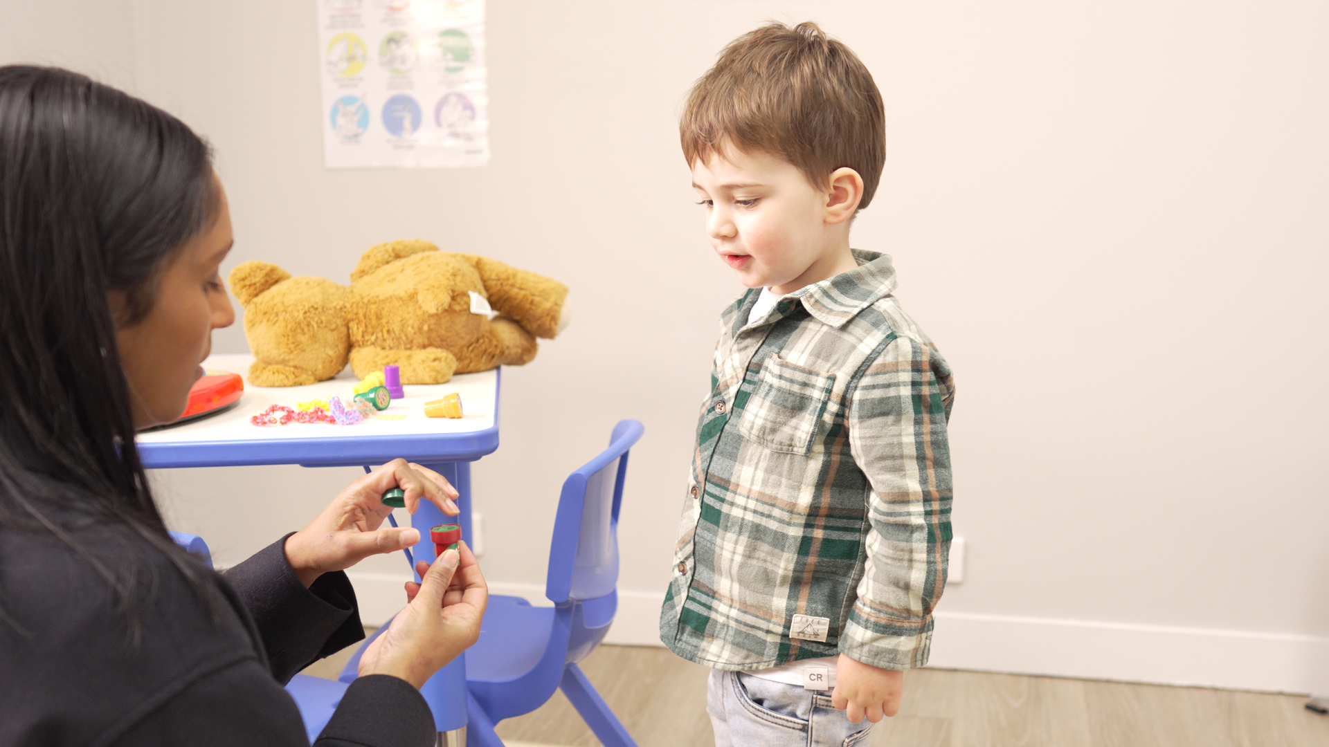 A woman is playing with a young boy in a room.