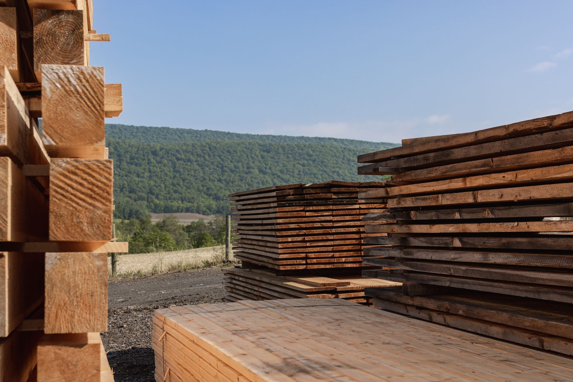 A pile of wood is stacked on top of each other in a yard.