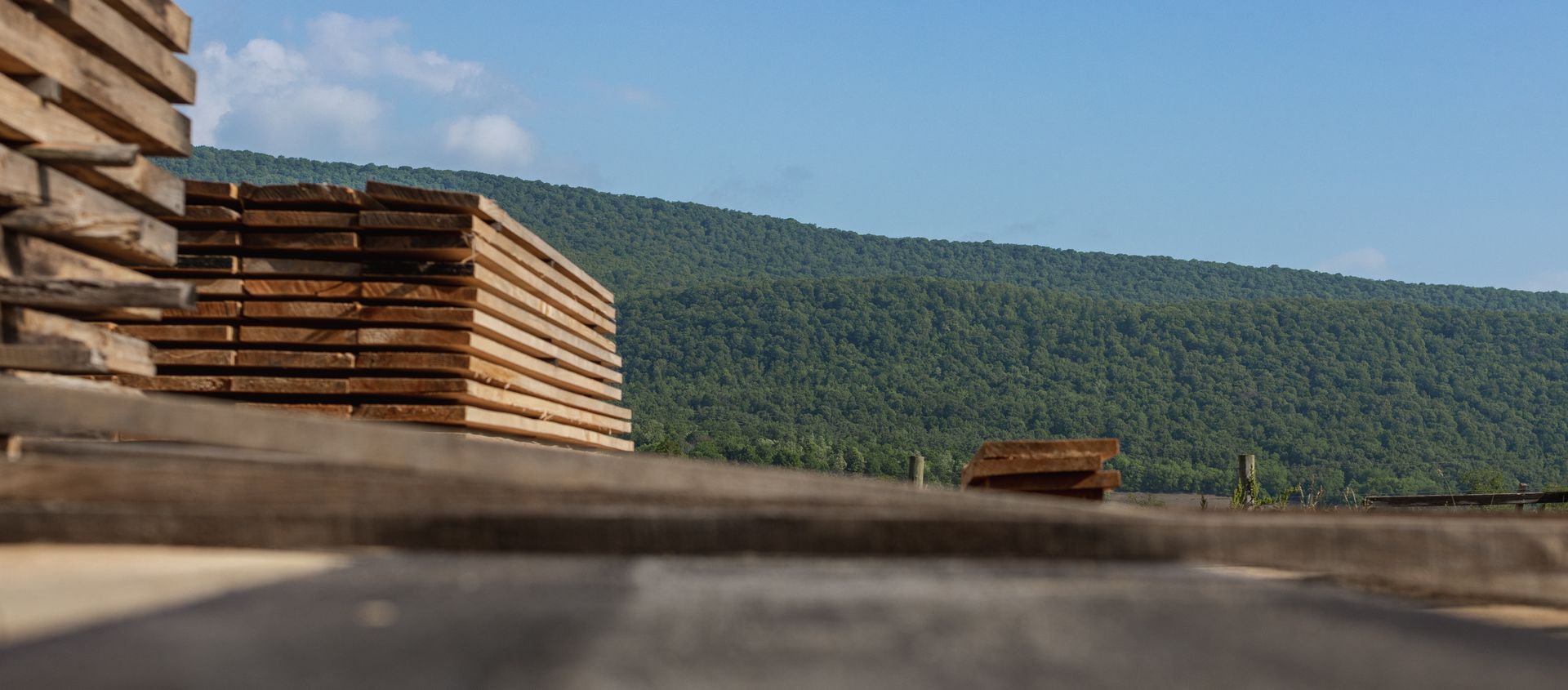 A stack of wooden boards is sitting in front of a mountain.