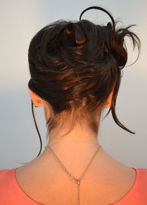 The back of a woman 's head with blonde hair in a bun