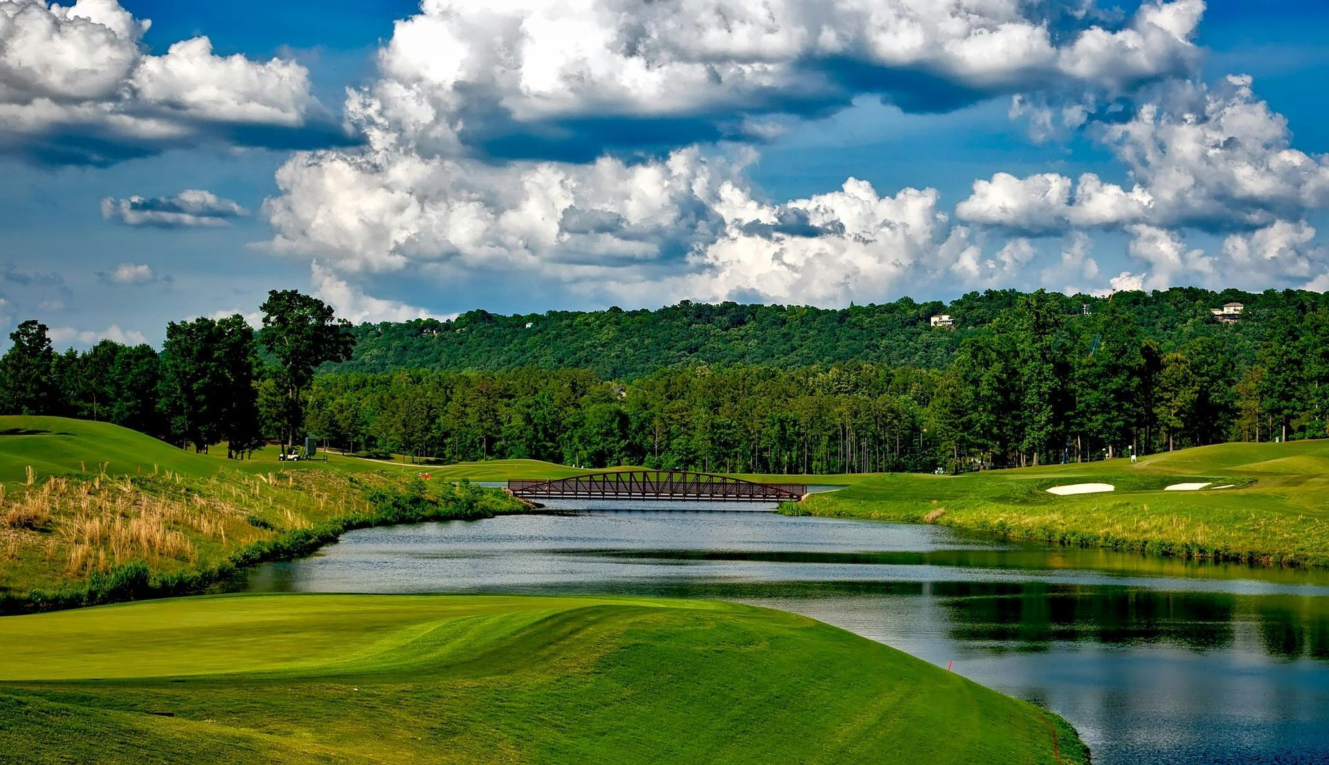 There is a lake in the middle of a golf course.