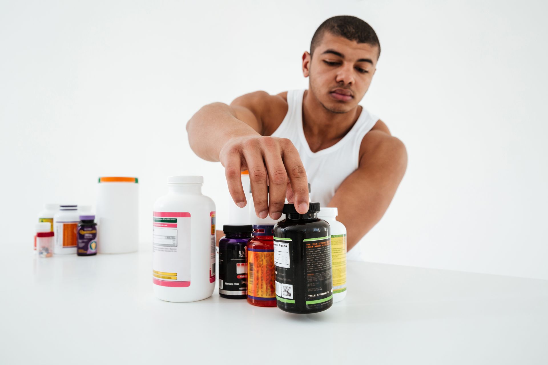 Two men are standing next to a bottle of water and a bottle of protein powder.