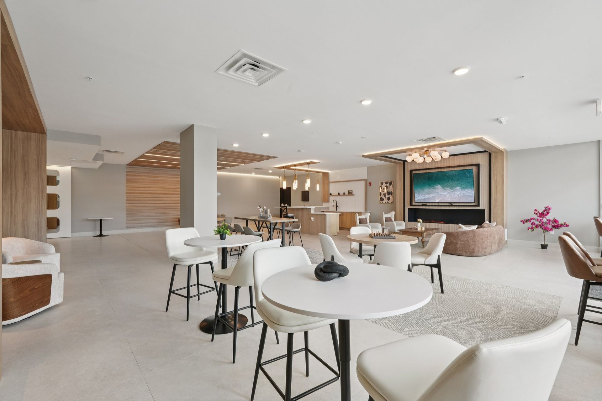 Apartment complex with a swimming pool, lounge chairs, and a sunny sky.