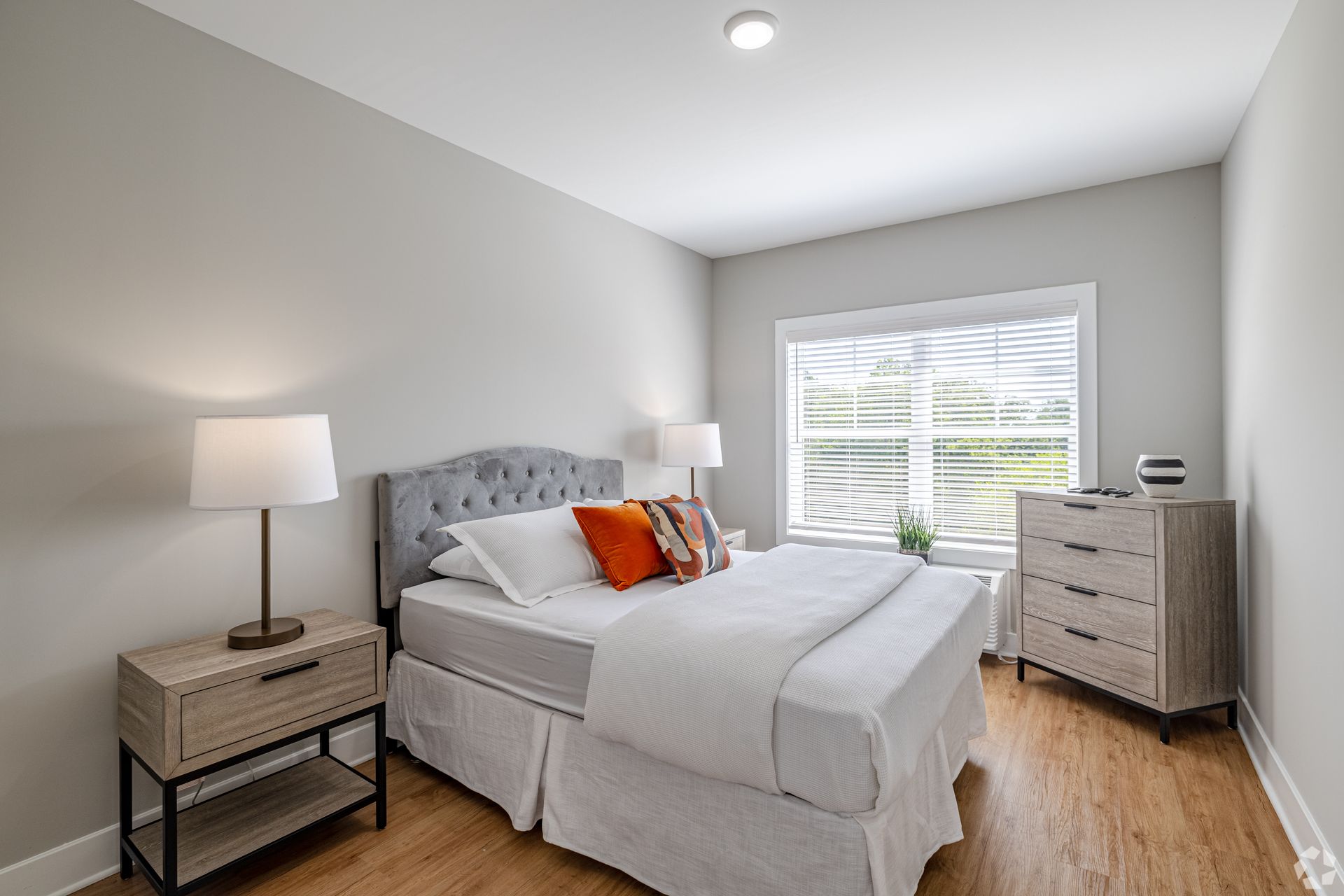 Swimming pool at an apartment complex, surrounded by lounge chairs, with buildings in the background.