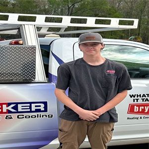 A young man is standing in front of a truck.