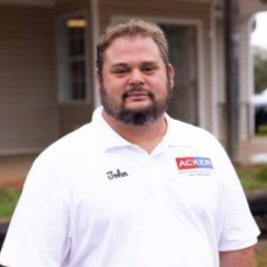 A man with a beard is wearing a white shirt with the name john on it.