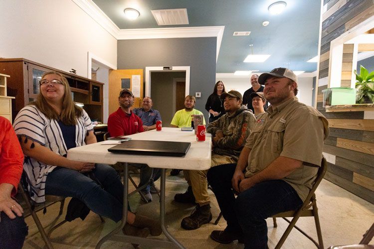 A group of people are sitting around a table in a room.
