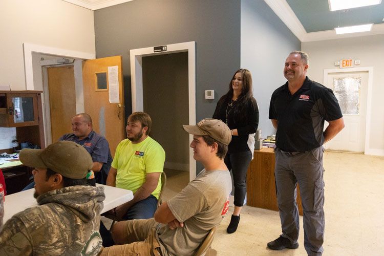 A group of people are standing around a table in a room.
