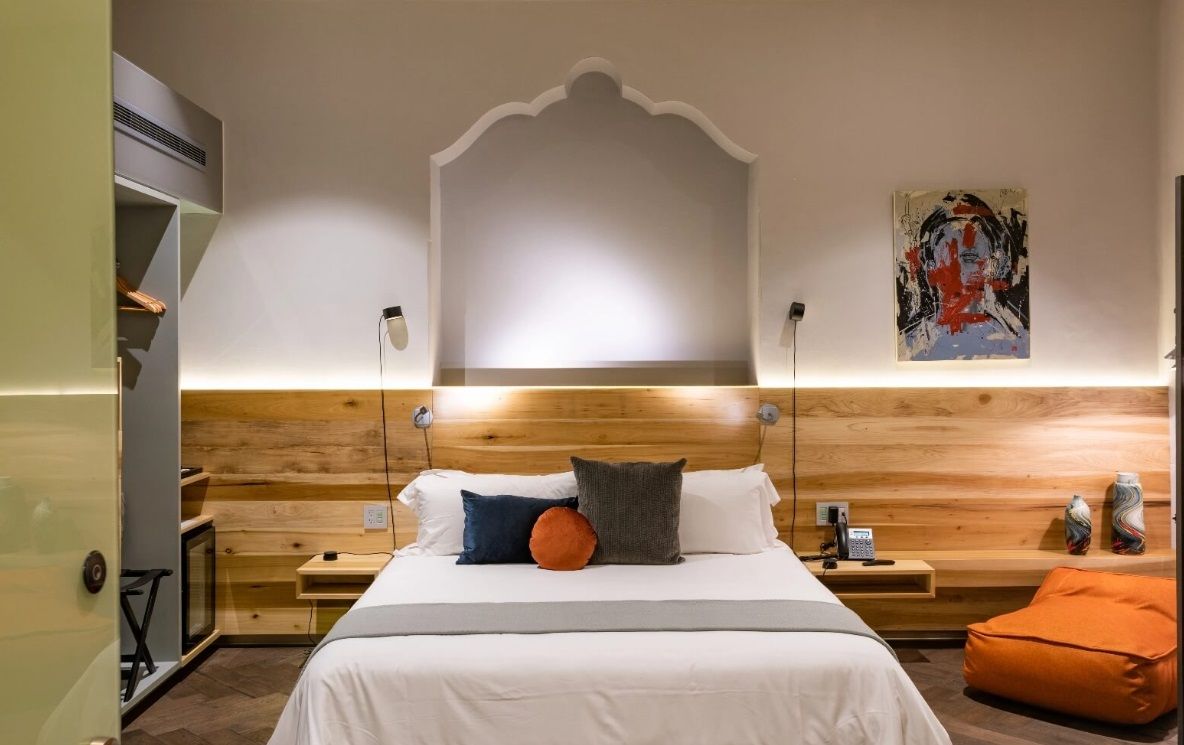 Un dormitorio con una cama grande y un cabecero de madera.