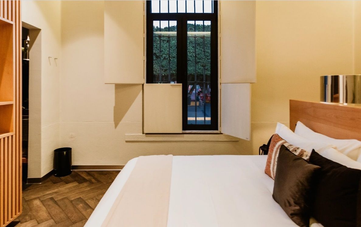 Una habitación de hotel con una cama y una ventana.