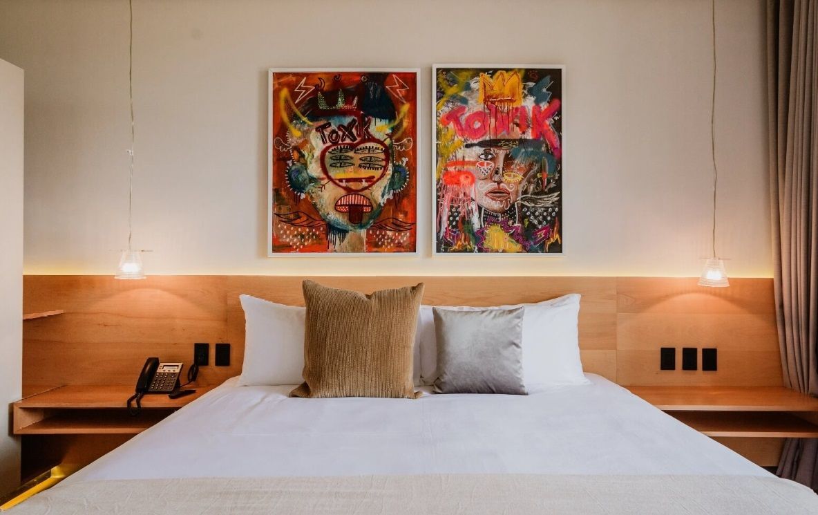 Hay dos cuadros en la pared encima de la cama.