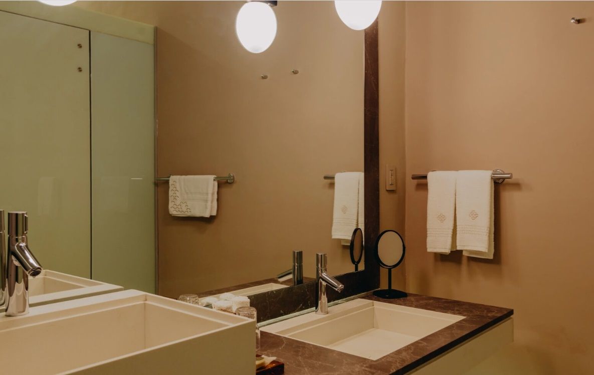 Un baño con dos lavabos y un espejo.