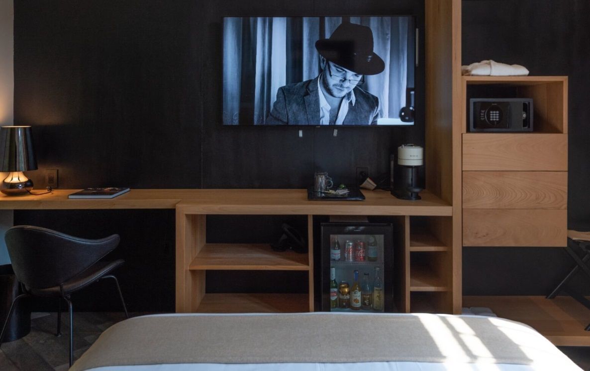Una habitación de hotel con un televisor de pantalla plana en la pared.