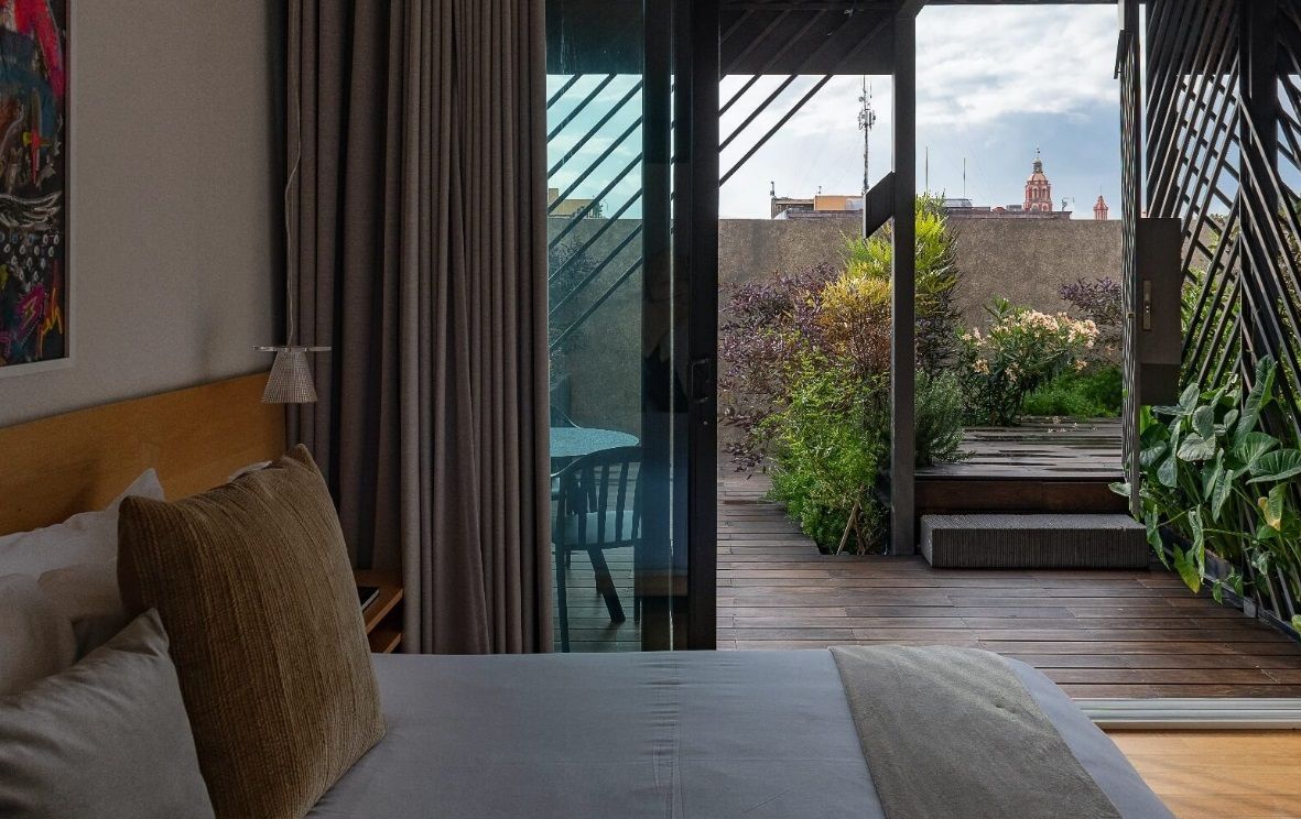 Un dormitorio con una cama y una puerta corrediza de vidrio que conduce a una terraza.