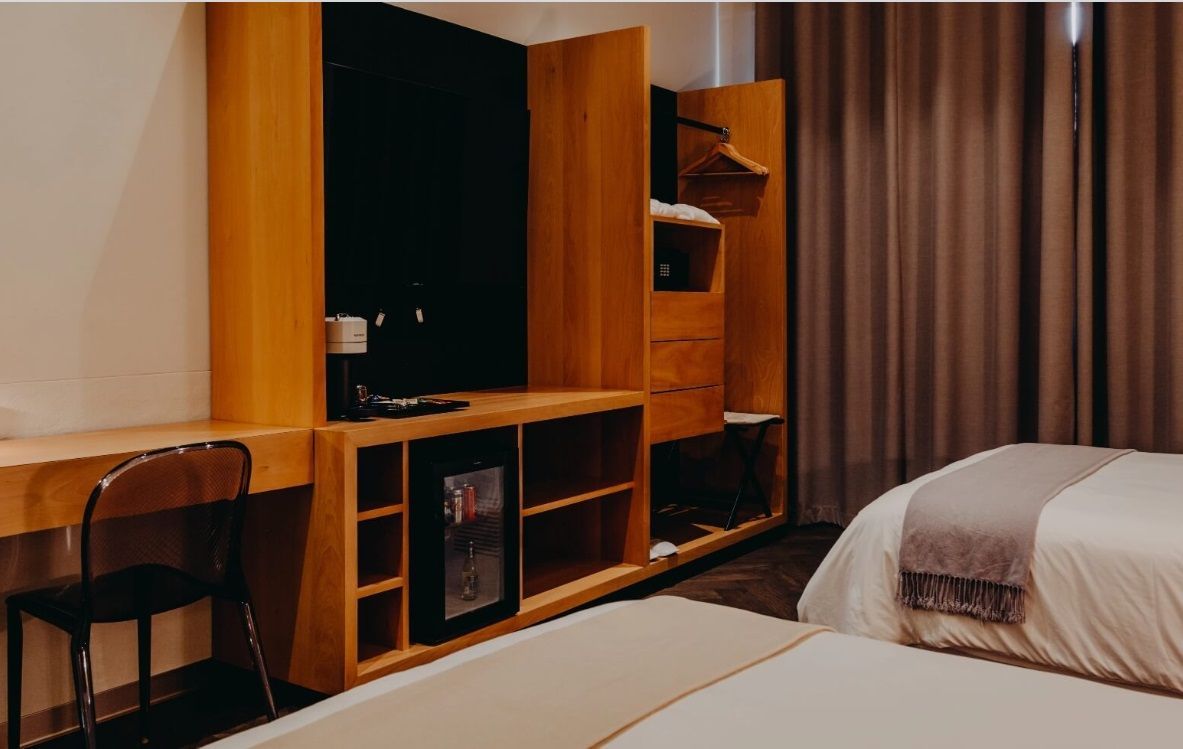 Una habitación de hotel con dos camas, un escritorio y una televisión.