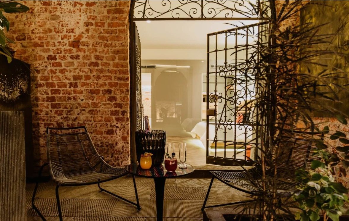 Hay una mesa y sillas frente a una pared de ladrillos.