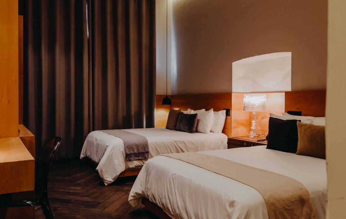 Una habitación de hotel con dos camas y un escritorio.