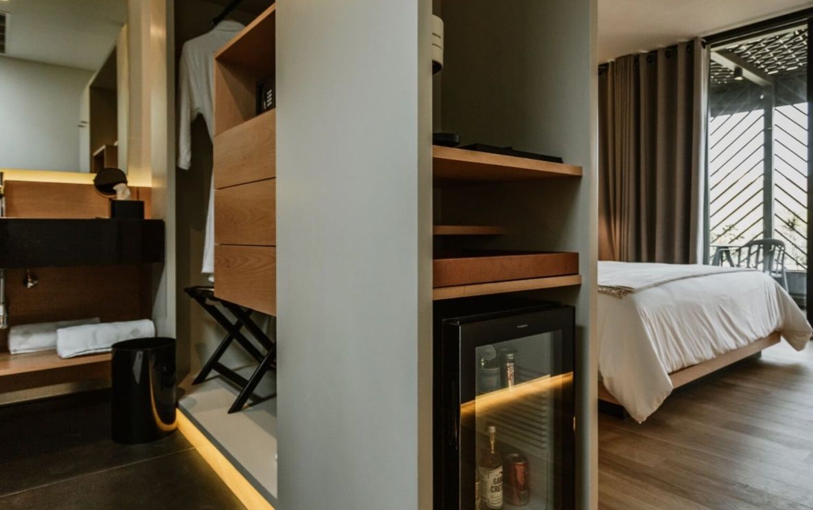 Una habitación de hotel con una cama y una nevera.